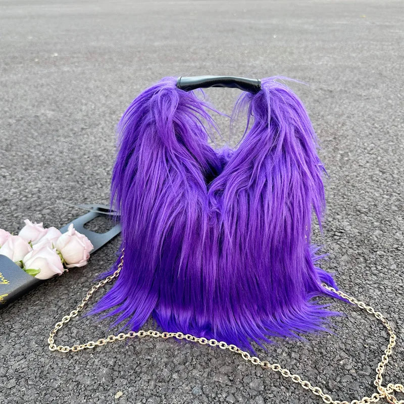 Purple fluffy handbag with a gold chain on a grey surface
