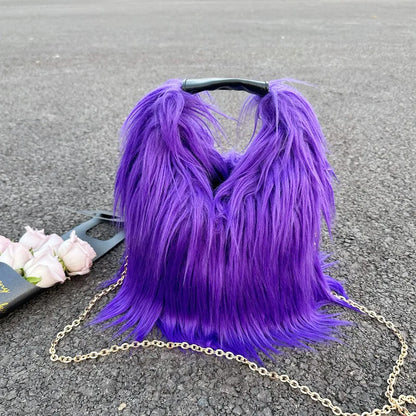 Purple fluffy handbag with a gold chain on a grey surface