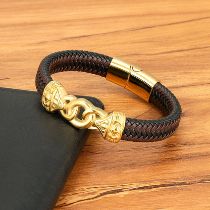 Brown braided leather bracelet with gold clasp on a wooden surface