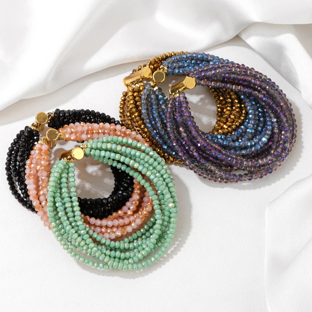Set of beaded bracelets in various colours on a white fabric background