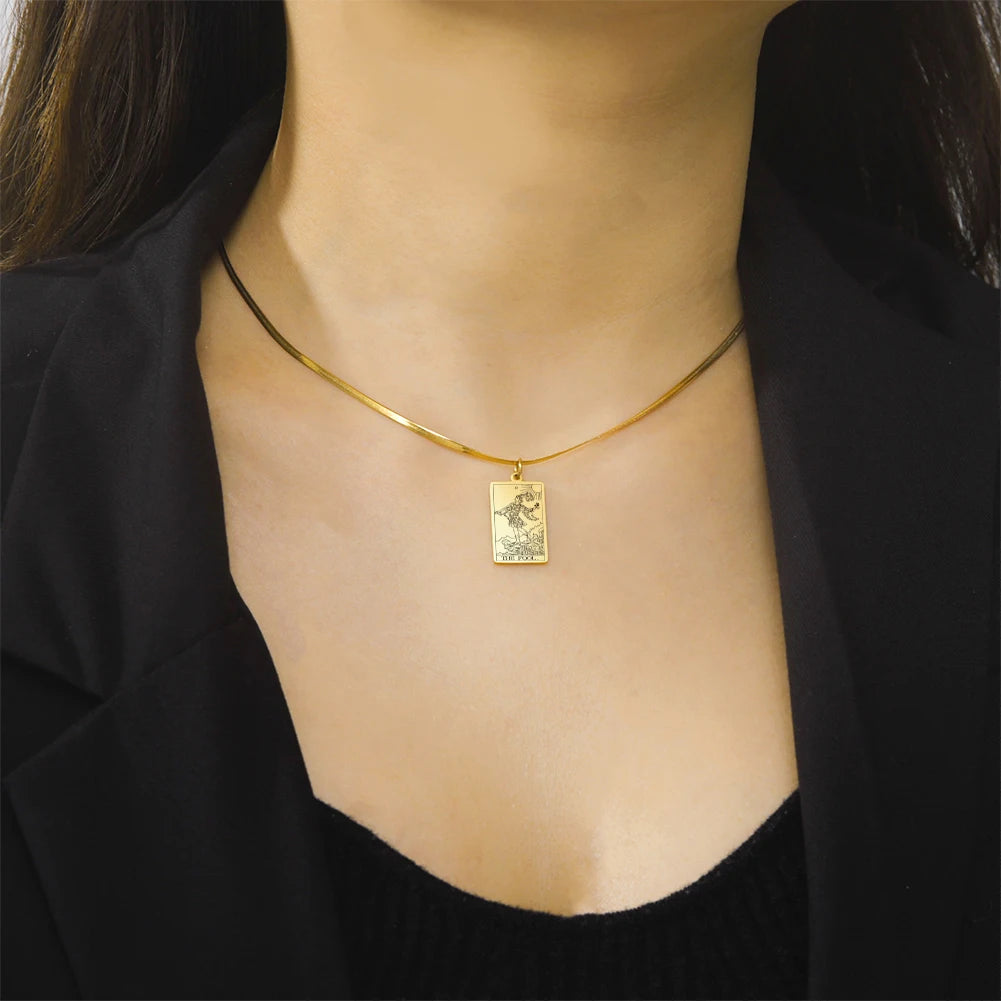 Gold necklace with a pendant on a person wearing a black top