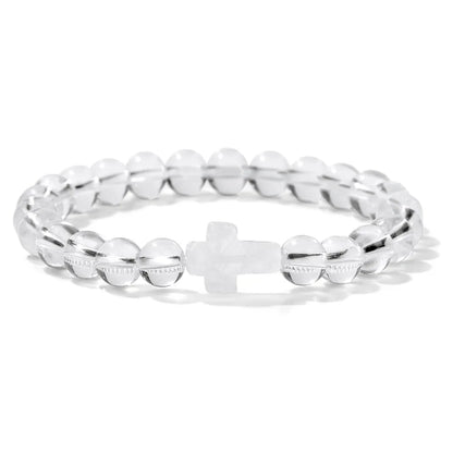 Transparent bracelet with a cross charm on a white background