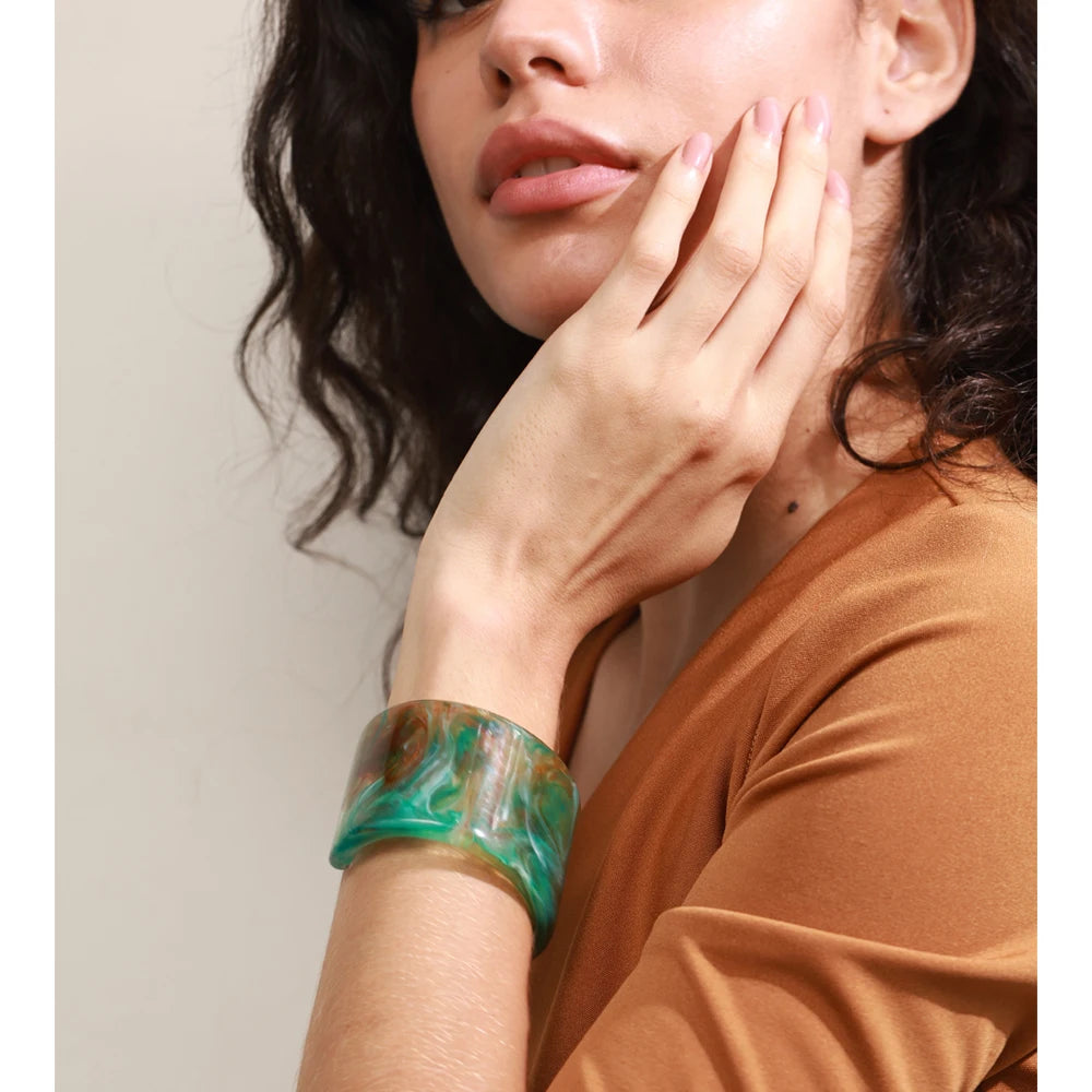 Woman wearing a green marbled bracelet on her wrist