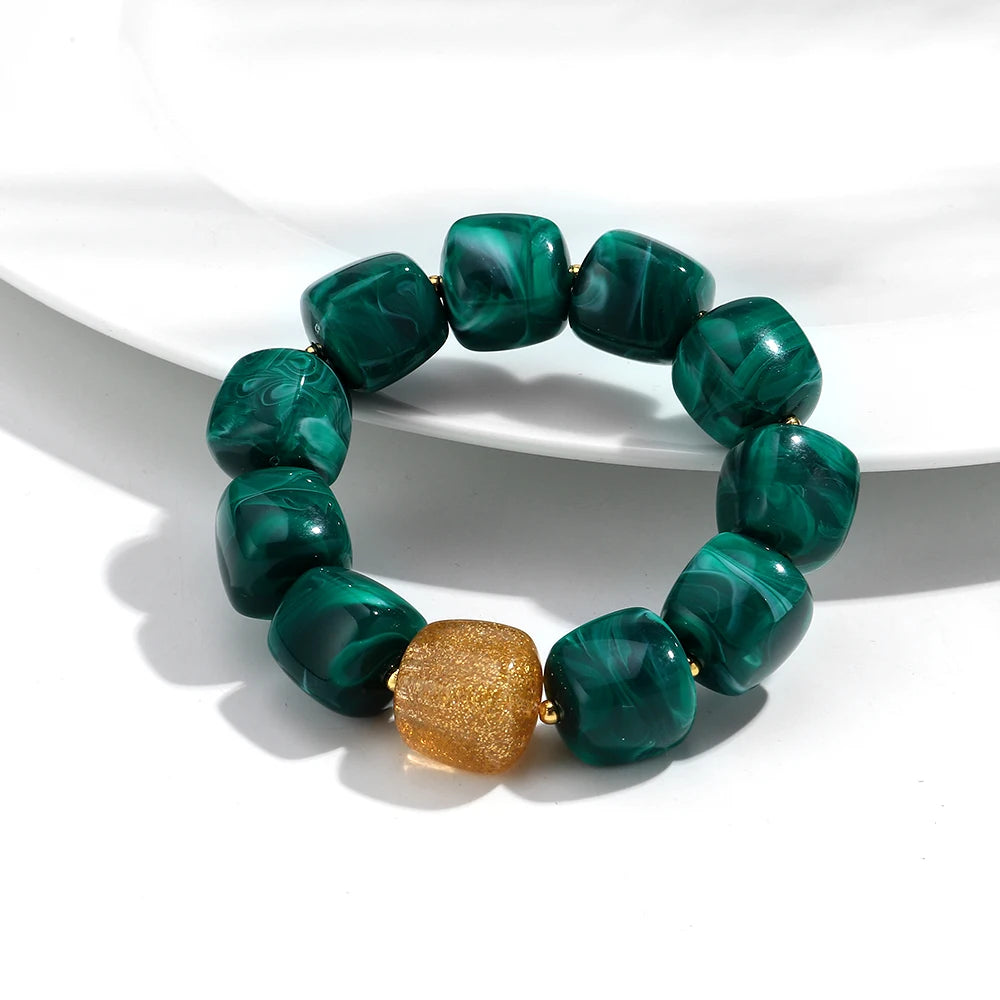 Green marbled bracelet with a gold accent on a white background