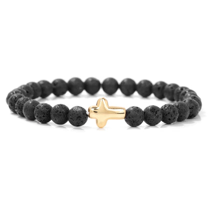 Black beaded bracelet with a gold cross charm on a white background