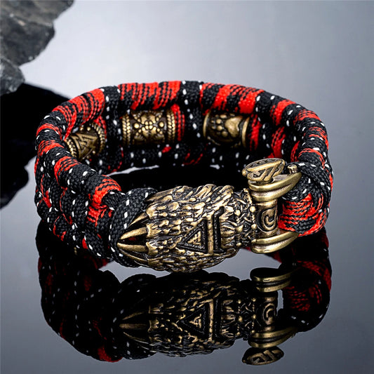 Bracelet with red, black, and gold design on a reflective surface