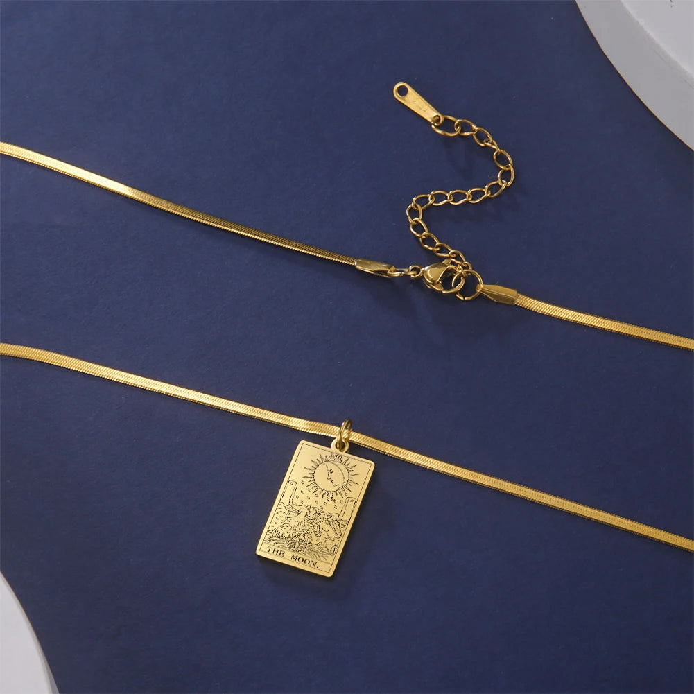 Gold necklace with a rectangular pendant on a blue fabric background