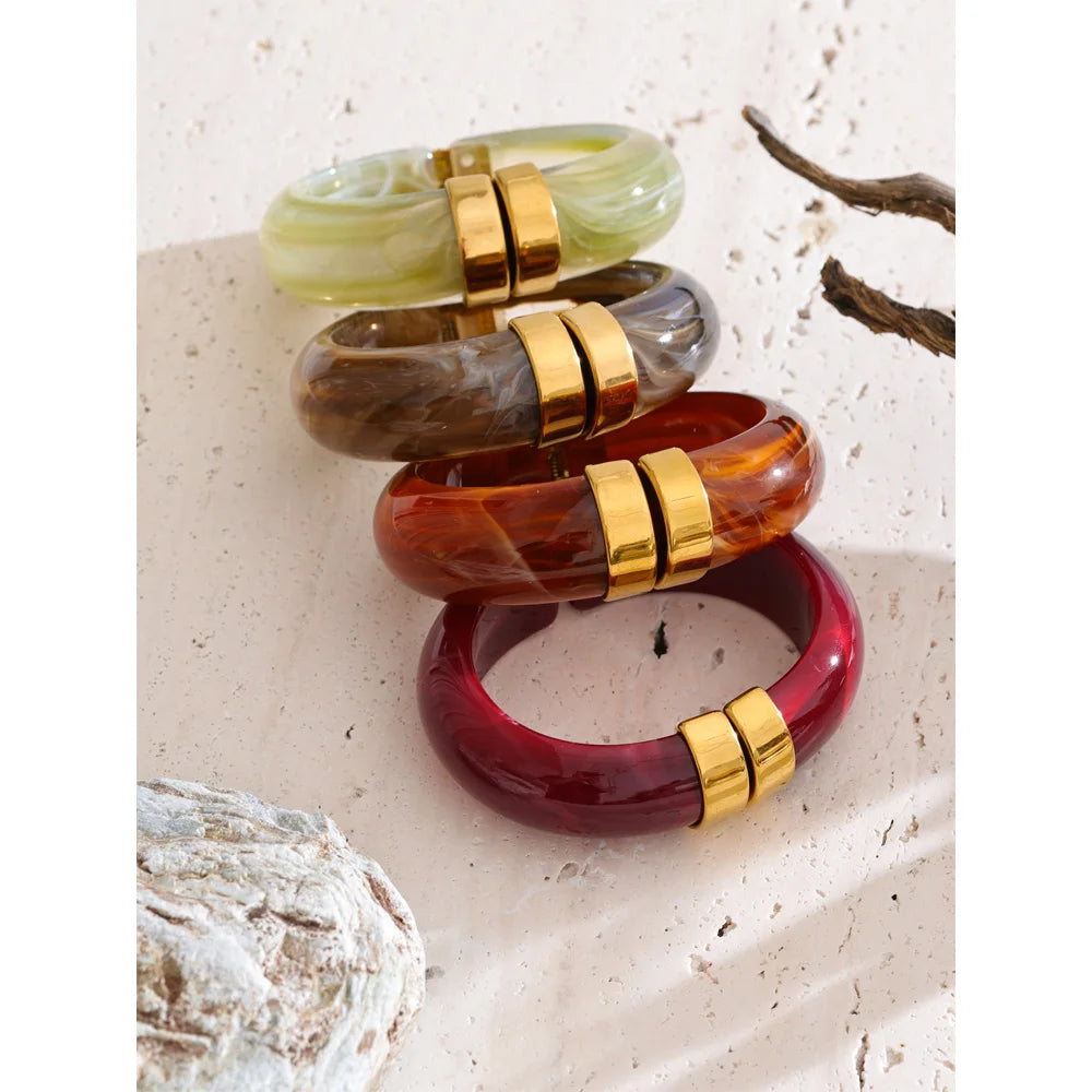 Set of colourful bangles with gold accents on a textured surface