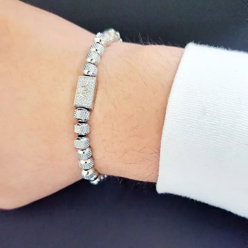 Silver beaded bracelet on a wrist with a dark background