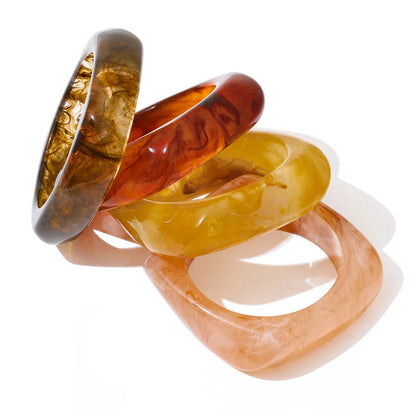 Set of four multicoloured bangles on a white background
