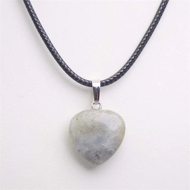 Heart-shaped stone pendant on a black cord against a white background