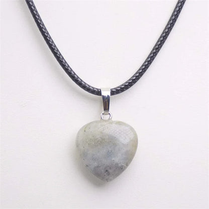 Heart-shaped stone pendant on a black cord against a white background