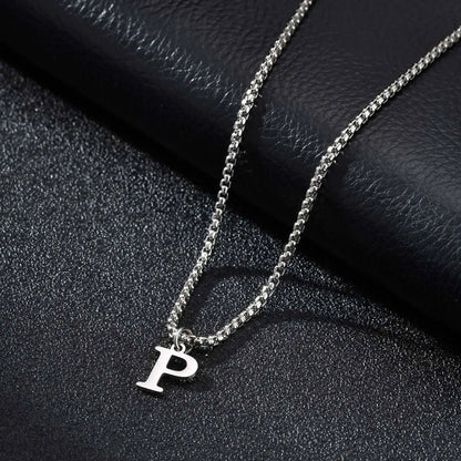 Silver necklace with a 'P' pendant on a dark textured surface