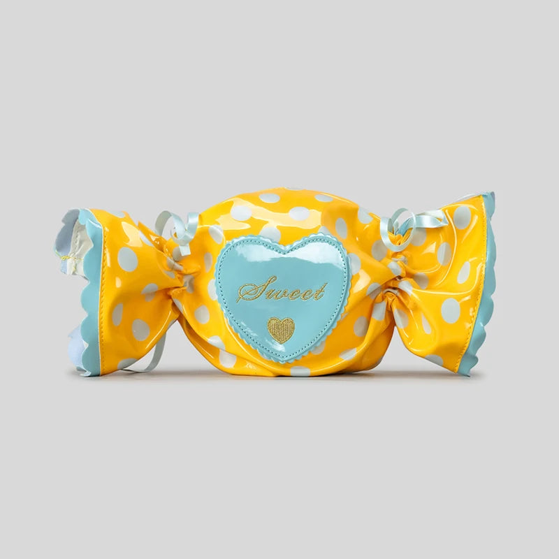 Yellow polka dot candy shaped bag with a blue heart label on a grey background