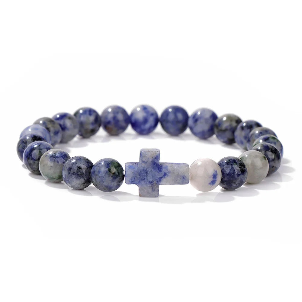 Beaded bracelet with blue and grey stones and a cross charm on a white background