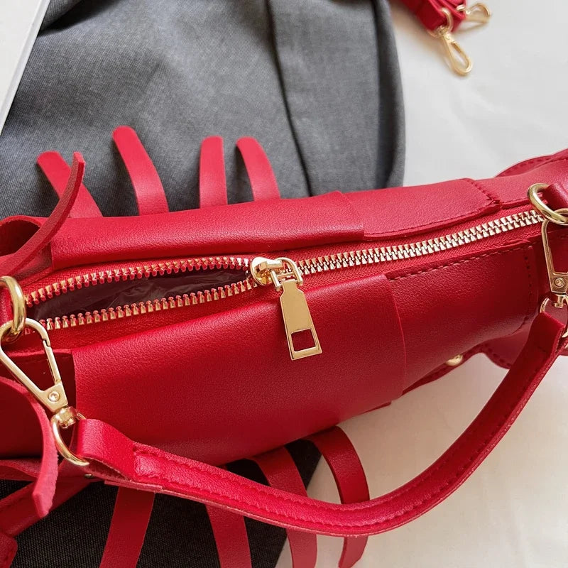 Red handbag with gold zippers and hardware on a neutral background