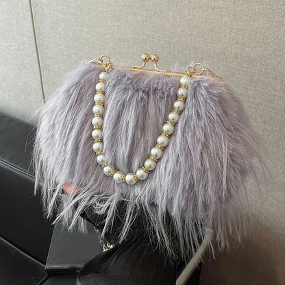 Handbag with feathered design and pearl embellishments on a textured surface