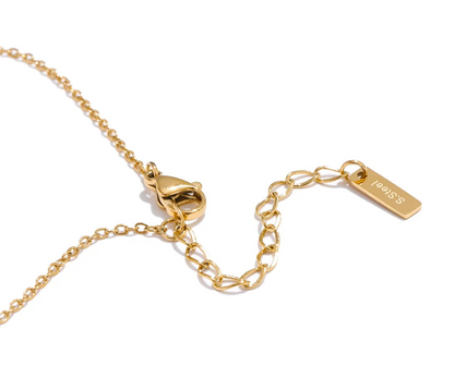 Gold necklace with clasp and tag on a white background