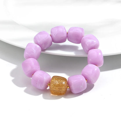 Purple beaded bracelet with a gold druzy stone on a white background