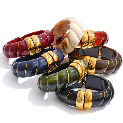 Set of colourful beaded bracelets with gold accents on a white background