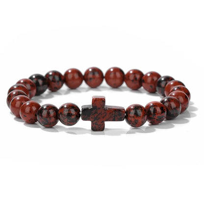 Bracelet with red and black beads and a cross charm on a white background