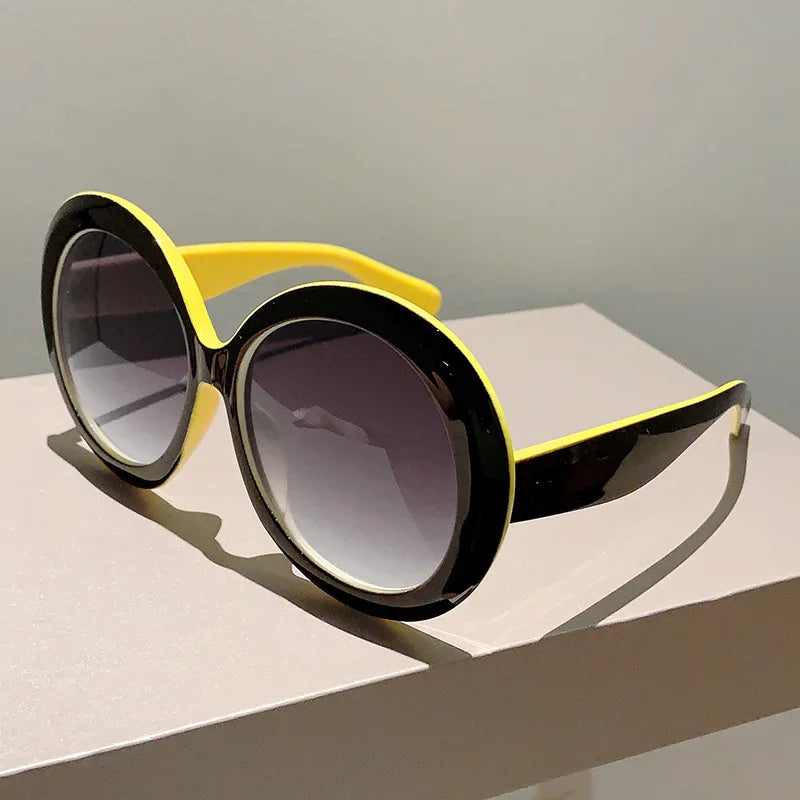 Sunglasses with black and yellow frame on a light surface