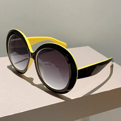 Sunglasses with black and yellow frame on a light surface