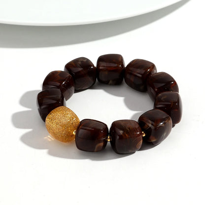 Brown beaded bracelet with a gold bead on a white background