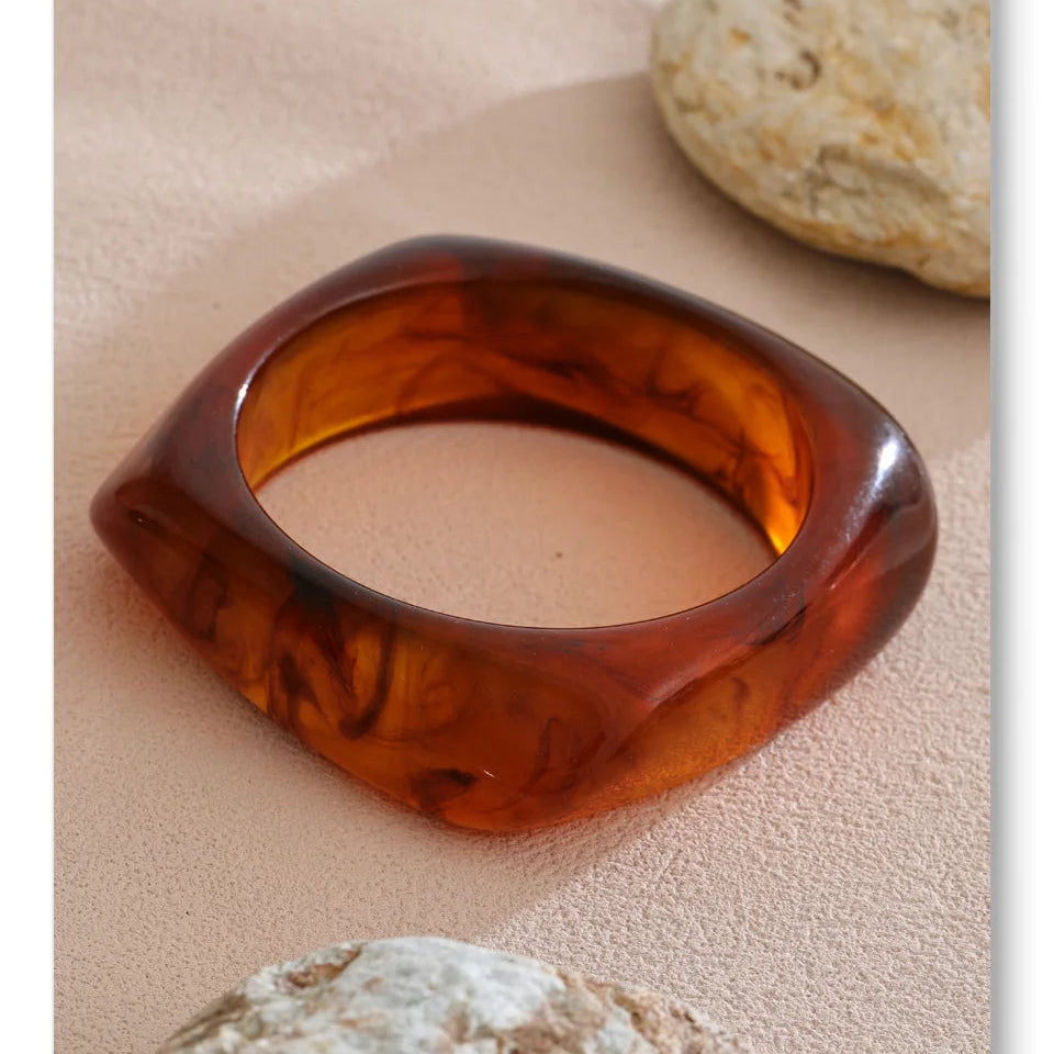Brown bangle on a sandy surface with rocks