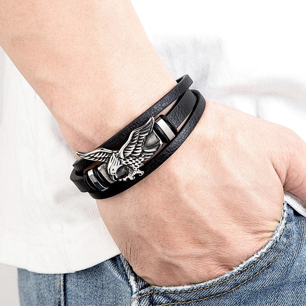 Black leather bracelet with an eagle emblem on a wrist.