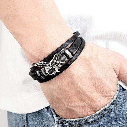 Black leather bracelet with an eagle emblem on a wrist.