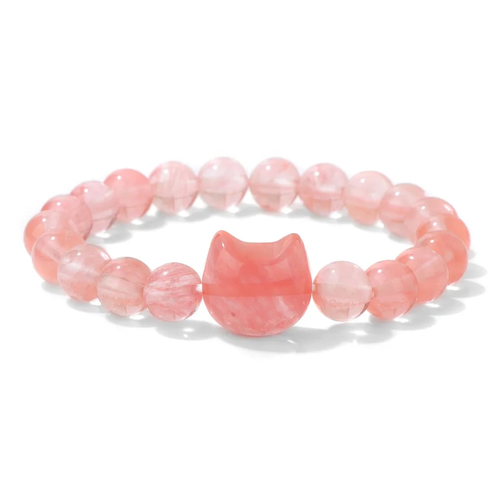 Pink beaded bracelet with a cat-shaped charm on a white background