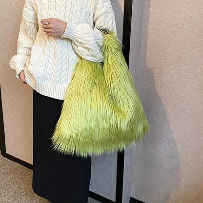 Person wearing a white cable knit sweater and holding a bright green fluffy bag.