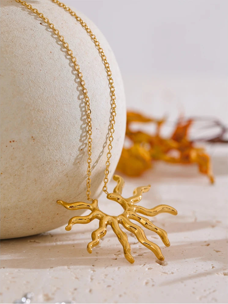 Gold necklace with a unique pendant on a textured surface