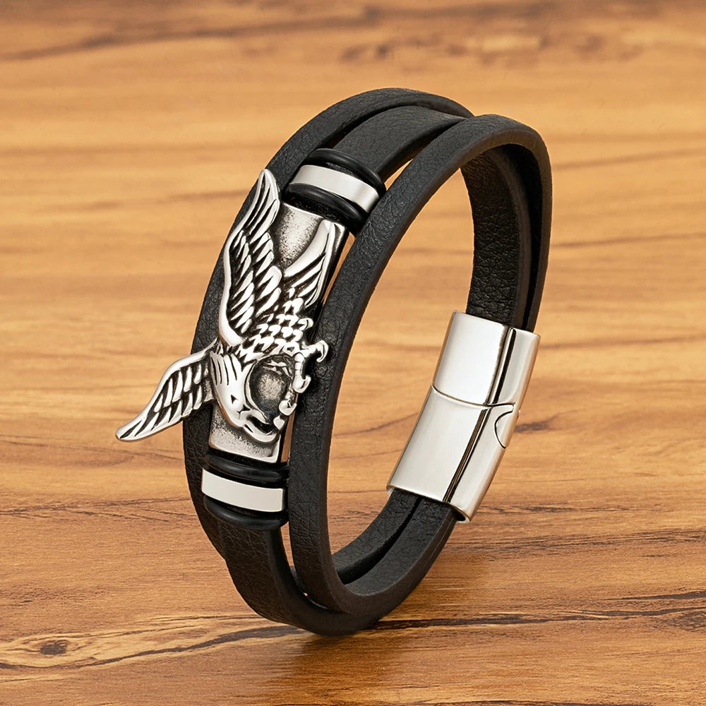 Black leather bracelet with silver eagle emblem on a wooden surface