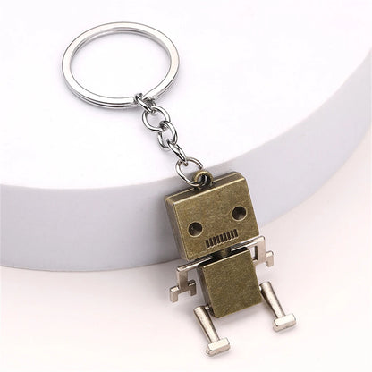 Gold metal robot keyring on white background