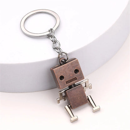 Bronze metal robot keyring on white background