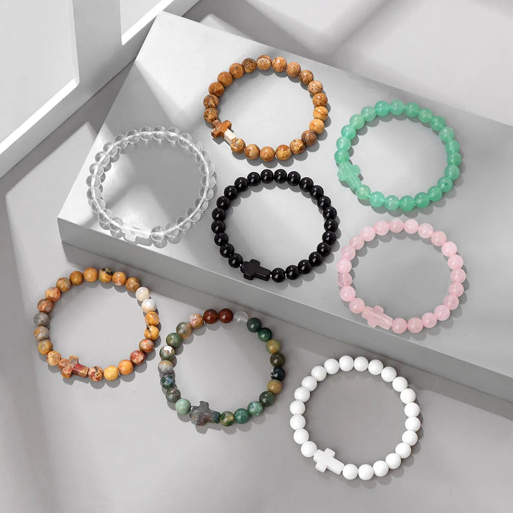 Set of beaded bracelets in various colours on a light grey surface