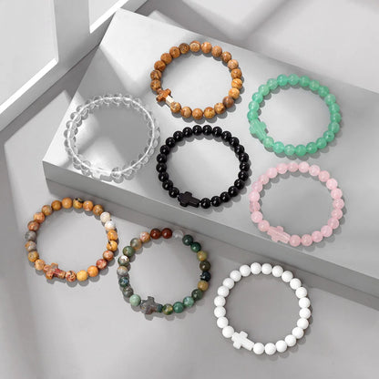 Set of beaded bracelets in various colours on a light grey surface