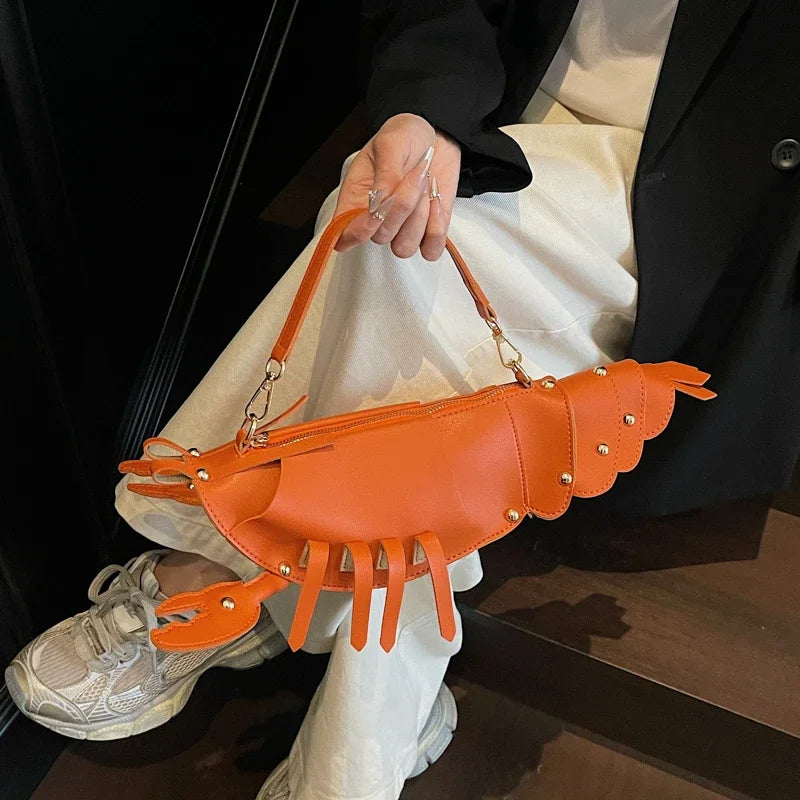 Person holding an orange lobster-shaped handbag with a neutral background