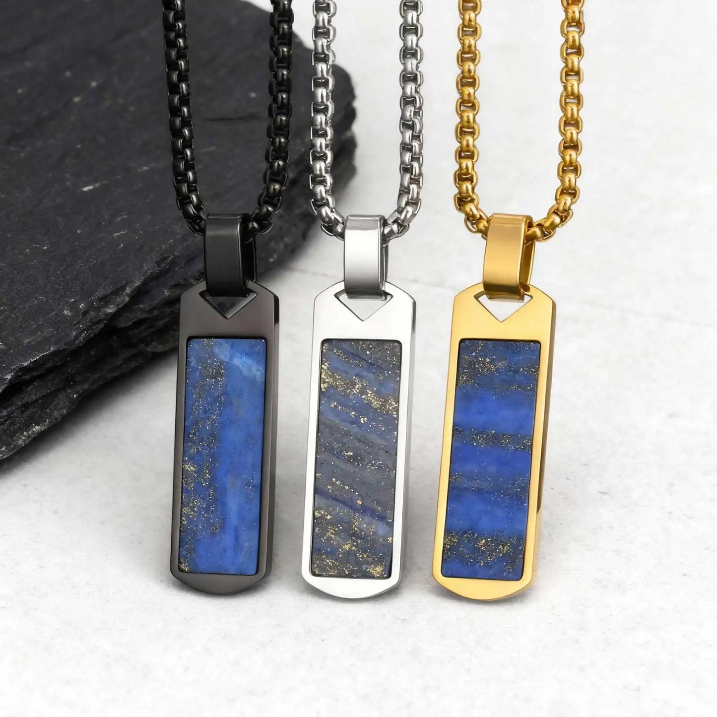 Three necklaces with blue stone pendants on black, silver, and gold chains.