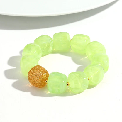 Neon green beaded bracelet with a gold bead on a white background