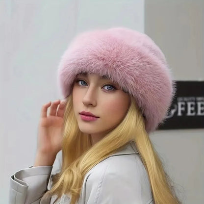 Woman wearing a pink fur hat against a plain background