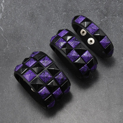 Three purple and black geometrically patterned objects on a grey surface