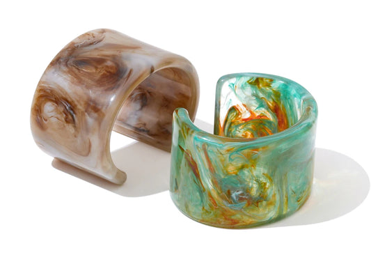 Two marbled cuff bracelets on a white background