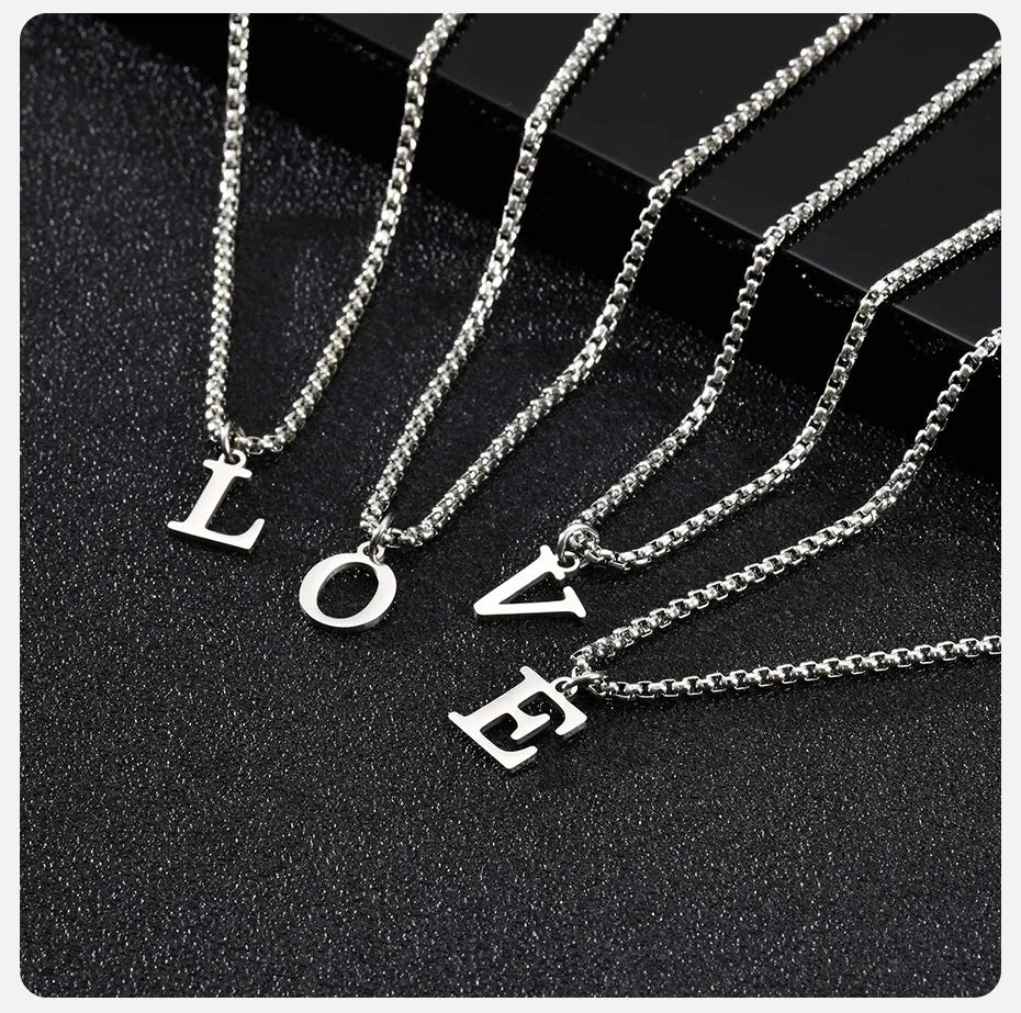 Silver necklaces with 'LOVE' pendants on a black background