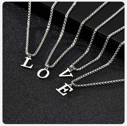 Silver necklaces with 'LOVE' pendants on a black background