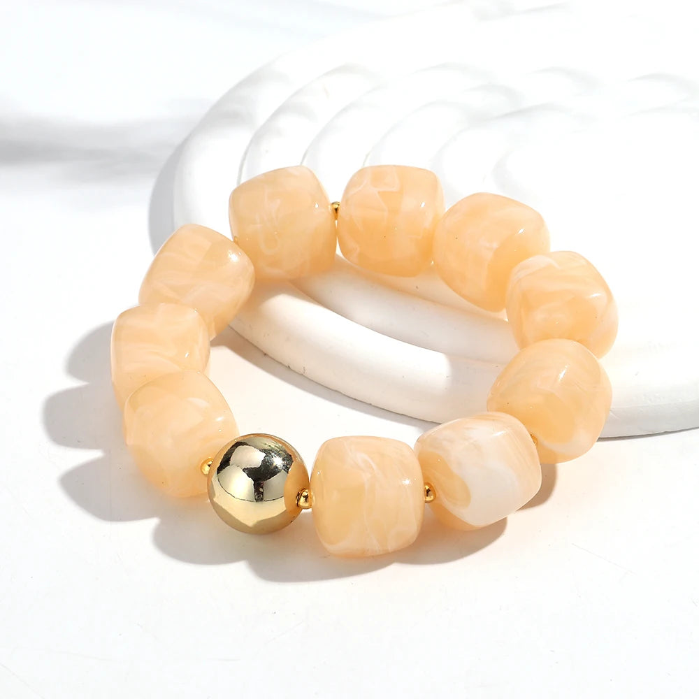 Beige beaded bracelet with a gold accent on a white background