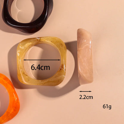 Transparent resin bangles with measurements on a beige background