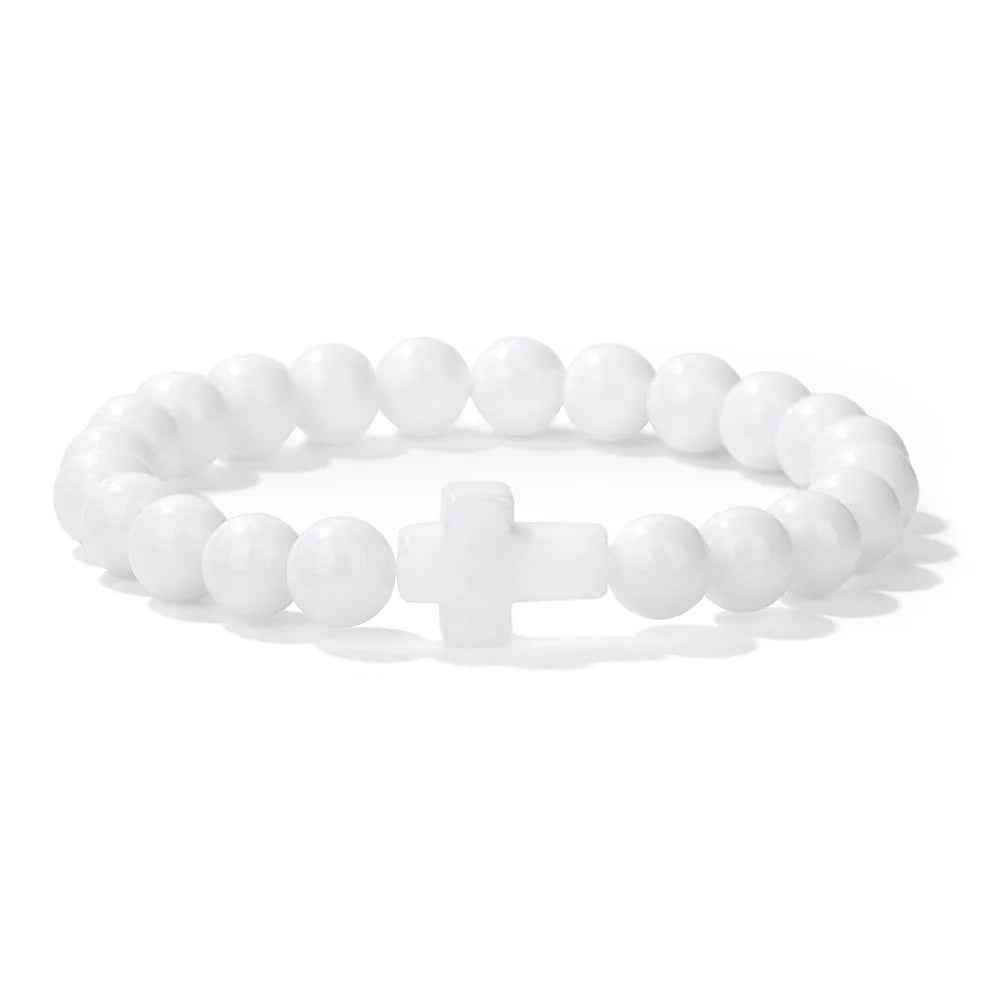 White beaded bracelet with a cross charm on a white background